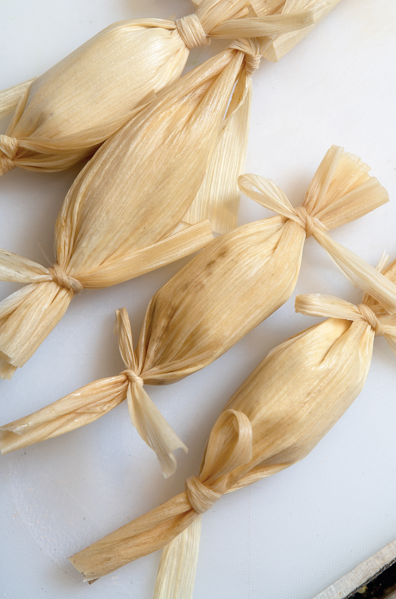 Bundles of pale lemongrass stalks tied with string on a light surface.